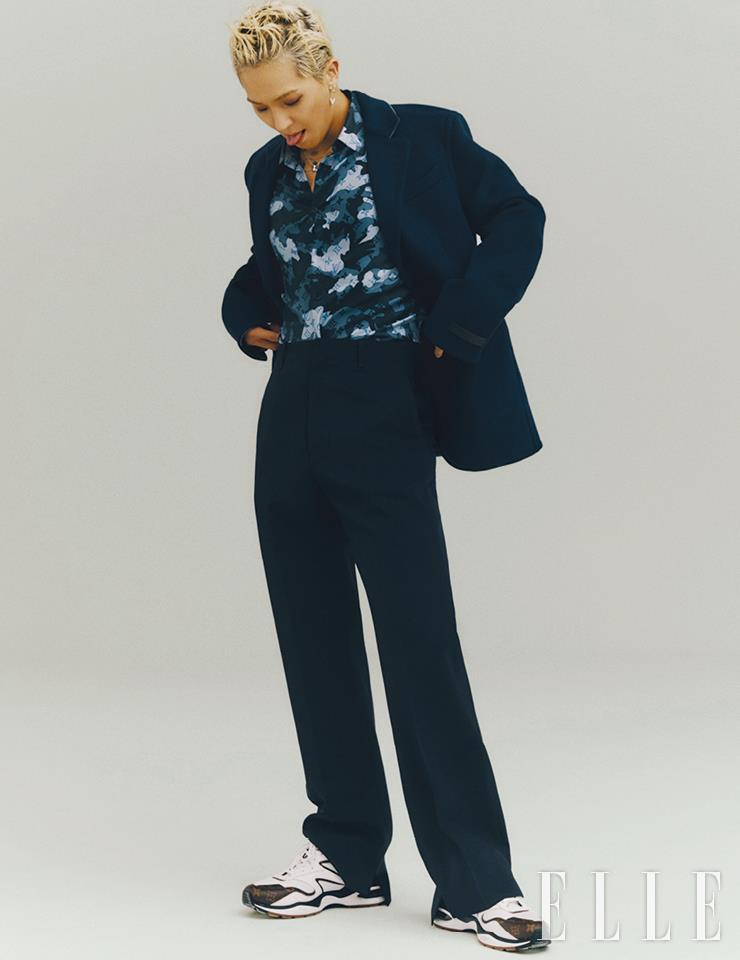클래식한 수트와 카무플라주 셔츠, 스니커즈는 모두 Louis Vuitton Men’s Collection. LV 볼트 파인 주얼리 업사이드 다운 이어링과 LV 볼트 파인 주얼리 원 네크리스는 모두 Louis Vuitton.
