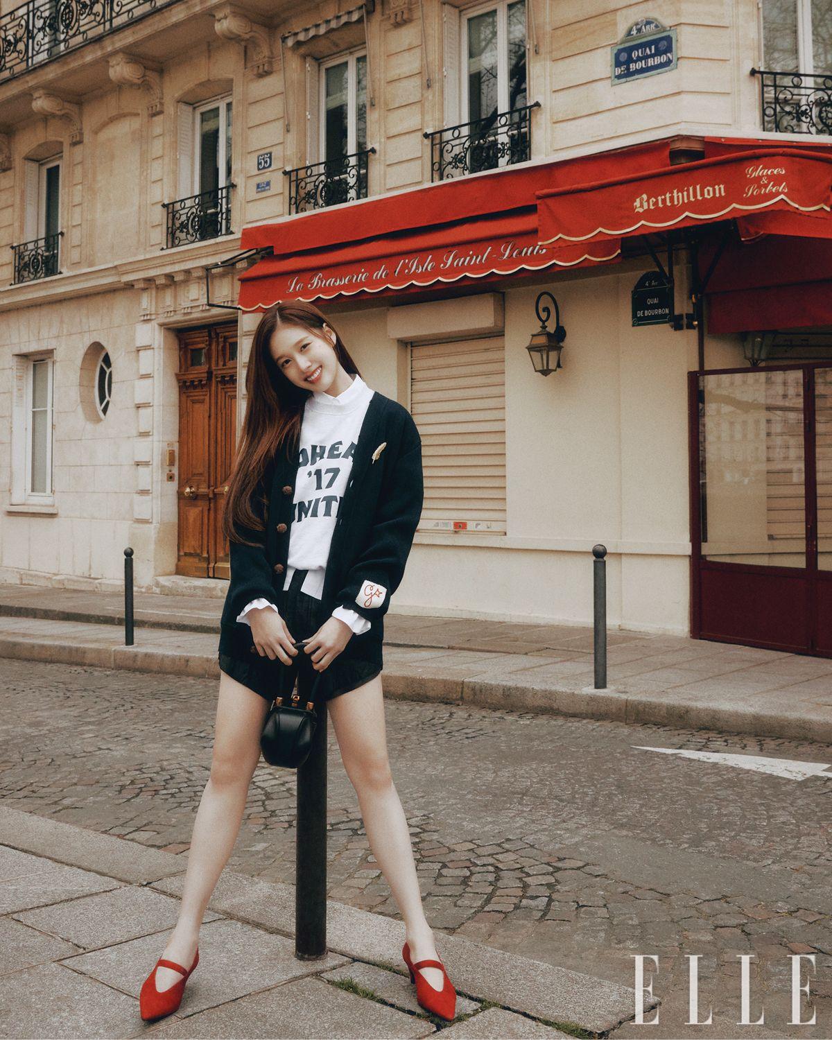 재이가 입은 자수 패치가 장식된 카디건은 Golden Goose. 스웨트셔츠와 레더 쇼츠는 모두 S/E/O. 화이트 셔츠는 Vivienne Westwood. 메리 제인 펌프스는 Toteme. 미니 사이즈 토트백은 Gabriela Hearst.