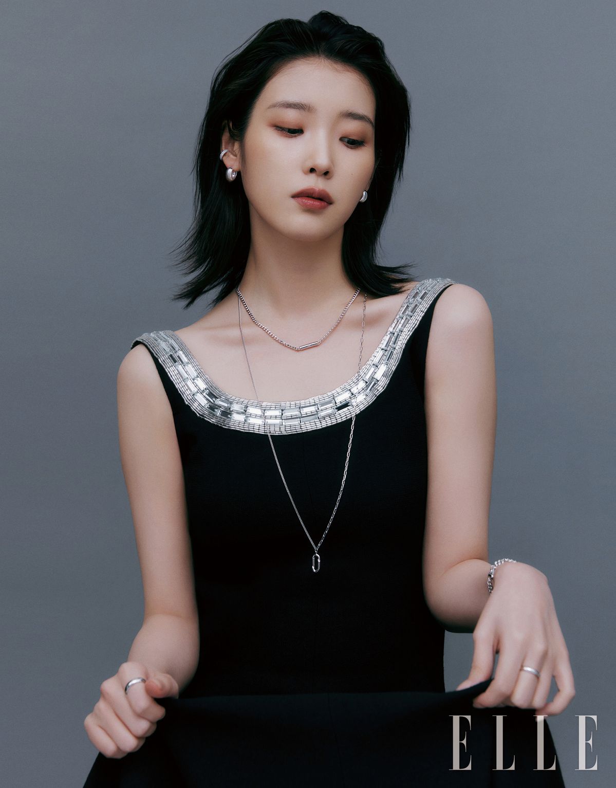 UNIS 스톤 세팅 이어커프는 5만8천원, UNIS 귀고리는 14만8천원, 레이어링한 짧은 UNIS 체인 목걸이는 23만8천원, 긴 UNIS 체인 목걸이는 21만8천원, UNIS 체인 팔찌는 15만8천원, 오른손 검지에 낀 UNIS 반지 M사이즈는 16만8천원, 왼손 중지에 낀 UNIS 반지 S사이즈는 14만8천원 모두 J.ESTINA. 큐빅 장식의 롱 드레스는 Chloe.