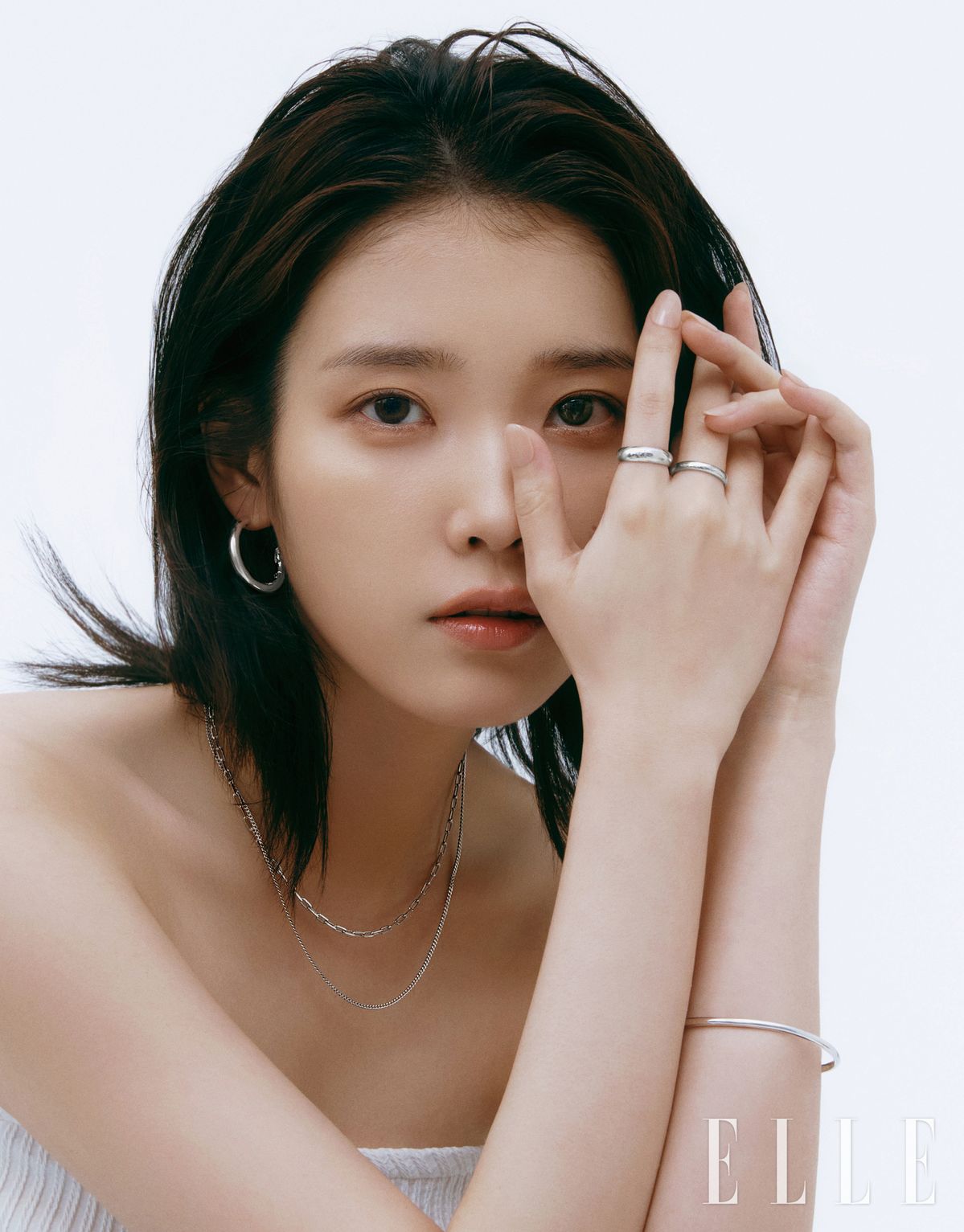 UNIS 반 후프 귀고리는 19만8천원, UNIS 체인 레이어드 목걸이는 21만8천원, 검지에 낀 UNIS 반지 M사이즈는 16만8천원, 중지에 낀 UNIS 반지 S사이즈는 14만8천원, UNIS 팔찌는 19만8천원 모두 J.ESTINA.