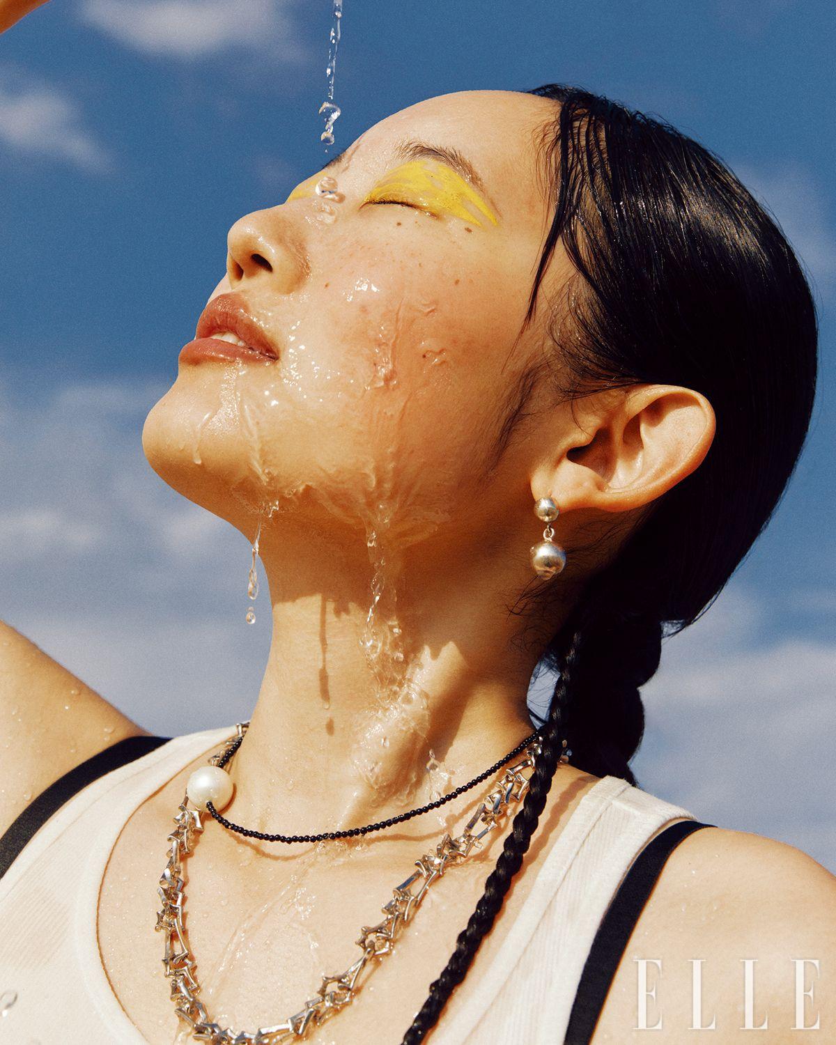 화이트 슬리브리스 톱은 Acne Studios. 이어링과 진주 네크리스는 Scho Jewerly. 체인 네크리스는 KVK.