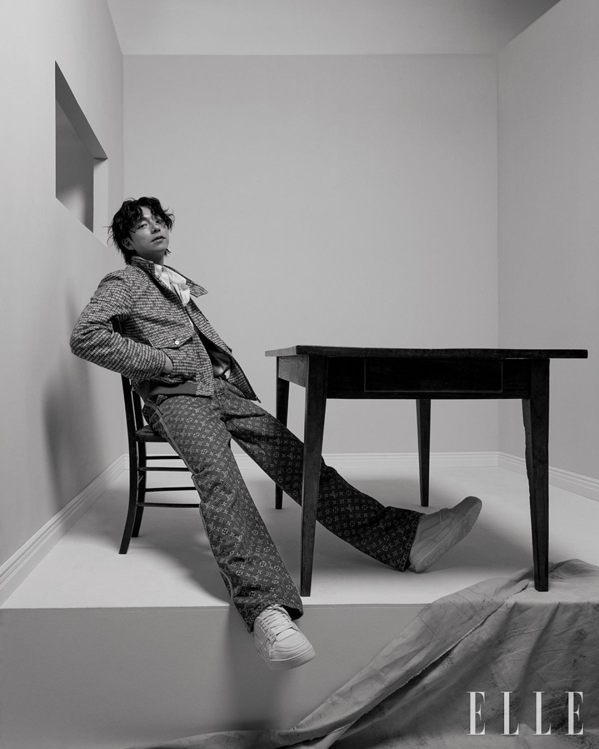 모노그램 패턴을 더한 헤링본 블루종 재킷과 화이트 셔츠, 모노그램 데님 팬츠, 화이트 ‘LV 트레이너’ 스니커즈는 모두 Louis Vuitton.