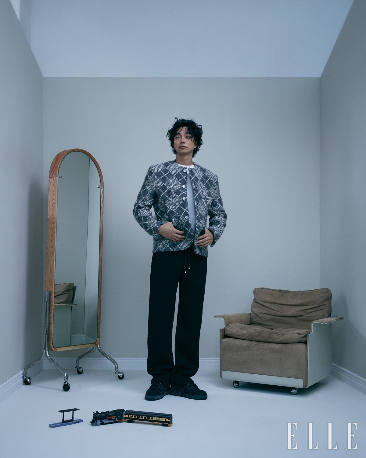 아가일 체크 패턴의 칼라리스 재킷과 화이트 티셔츠, 블랙 니트 팬츠, ‘LV 트레이너’ 스니커즈는 모두 Louis Vuitton. 