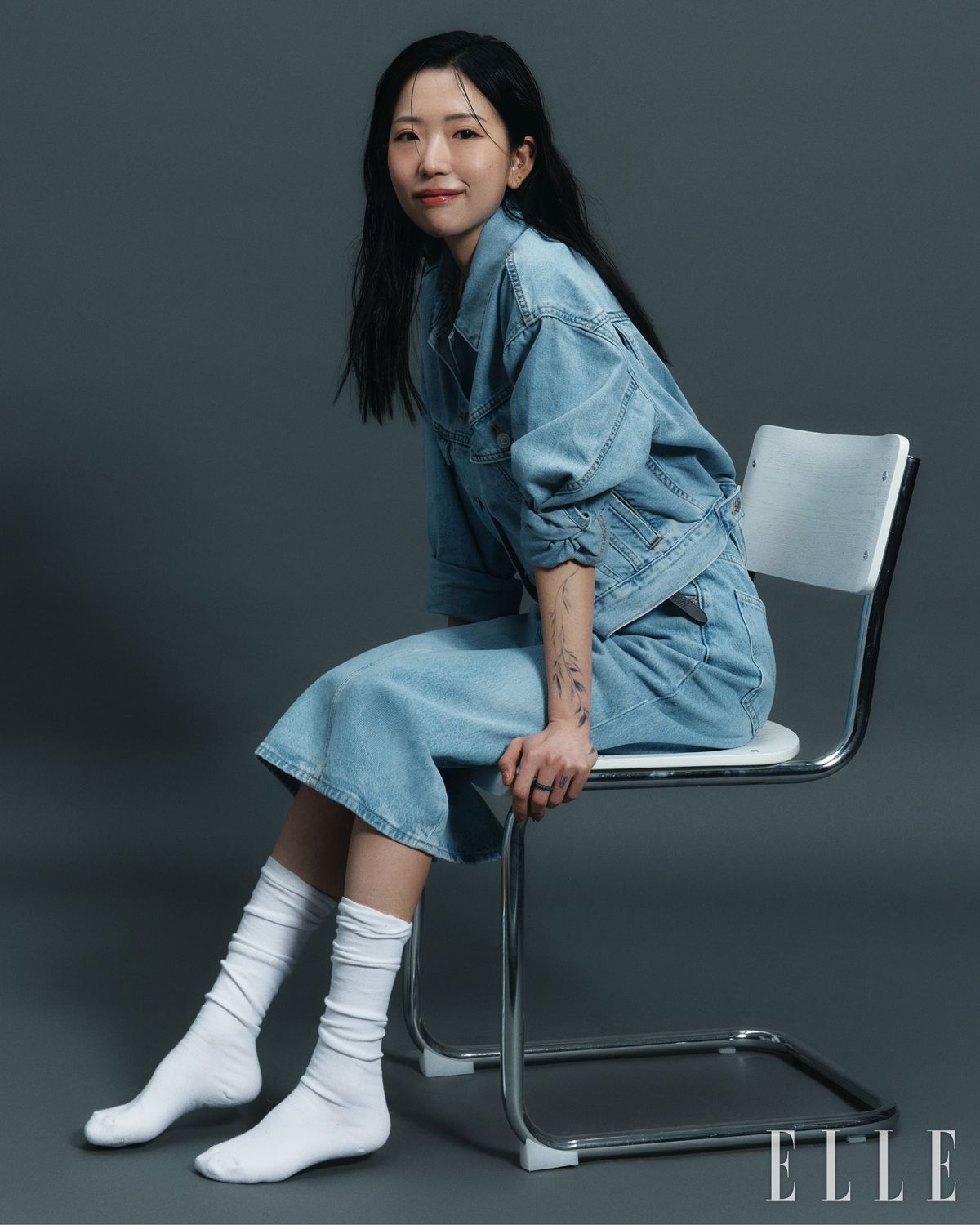 독특한 피치 실루엣과 크롭한 기장감이 돋보이는 슈렁큰 90s 트러커 자켓과 허리 라인을 안정감 있게 잡아주는 하이라이즈 슬릿 스커트는 모두 Levi's.