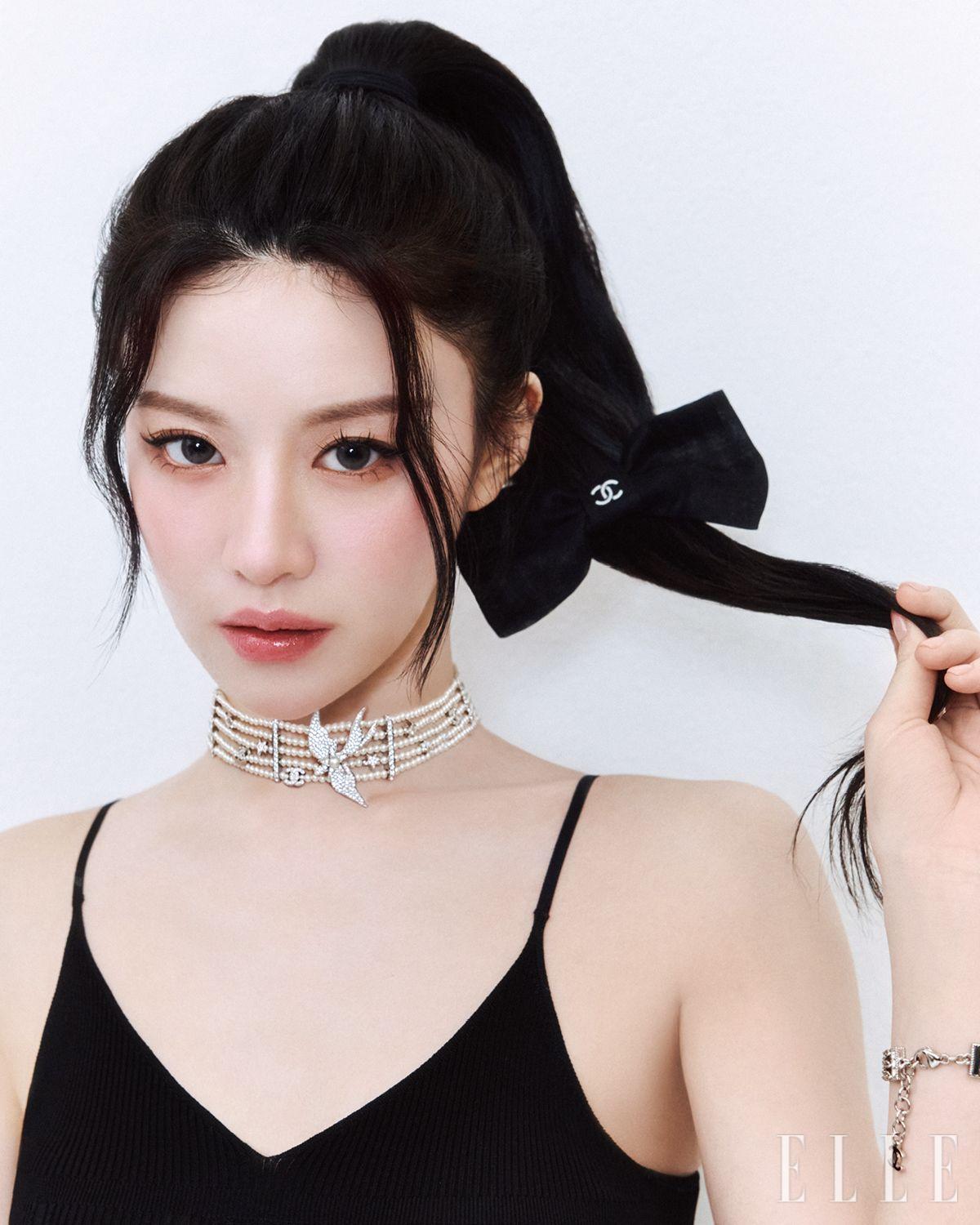  고윤정이 입은 슬리브리스 니트 톱과 리본 헤어핀, 새 장식의 진주 네크리스와 브레이슬릿은 모두 Chanel. 