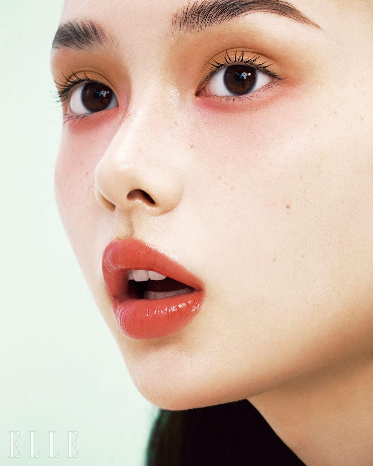우아한 코럴 컬러와 싱그러운 핑크 컬러가 대비를 이루는 아이 메이크업. 에밀리의 우묵한 아이홀에 레 꺄트르 옹브르, 268 깡되르 에 엑스뻬리앙스의 연한 브라운 섀도를 넓게 펴 바르고, 브릭 레드 섀도를 눈 밑 애굣살에 발라준다. 눈 밑에 바른 컬러를 그대로 양볼과 콧등까지 흩뿌리듯 터치해 눈가와 자연스럽게 이어지도록 연출하고, 르 루쥬 듀오, 192 코랄 핑크를 매치해 화사함을 더해준다. 사용 제품은 모두 Chanel.