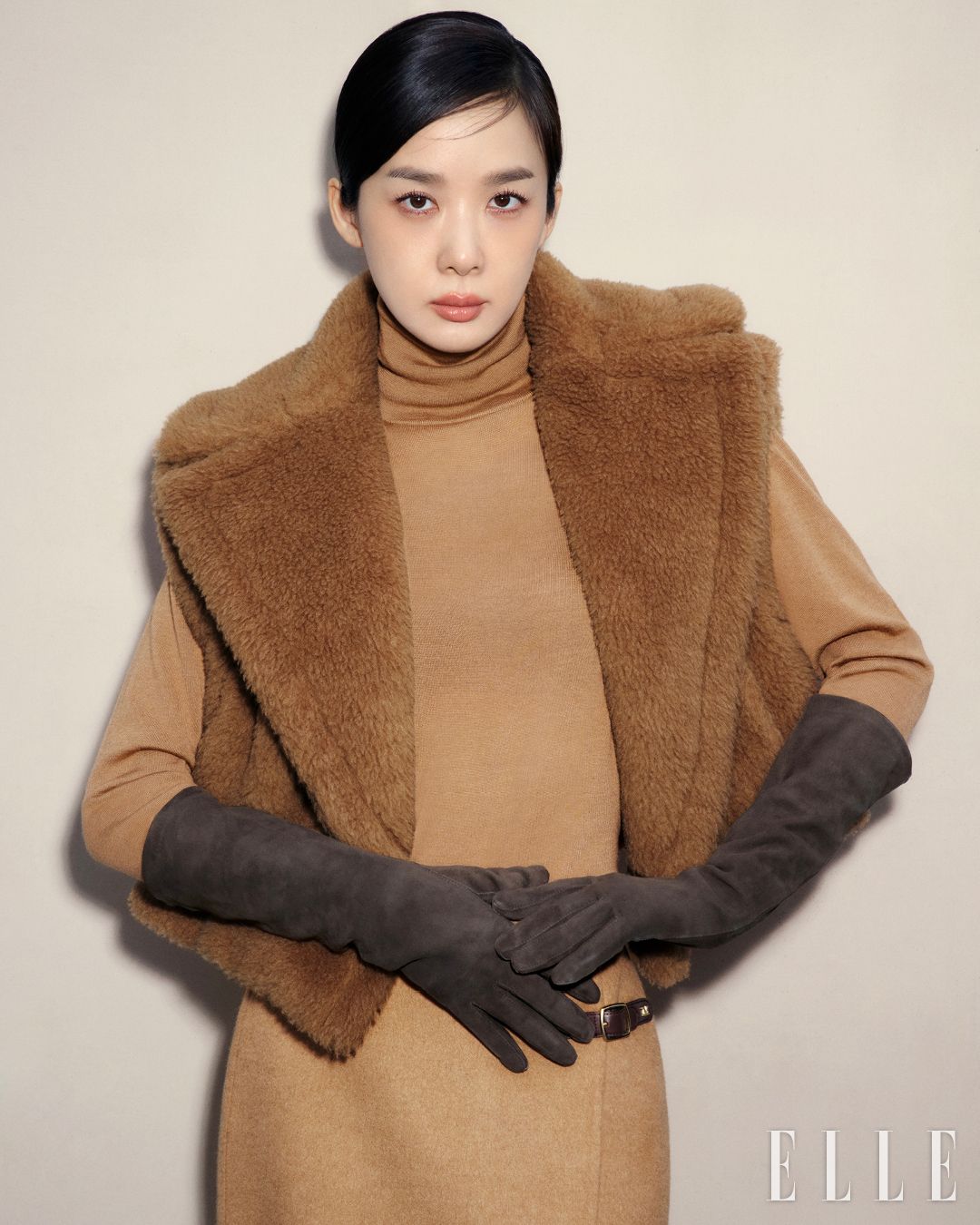 테디베어 아이콘 코트 크롭, 폴로 넥 스웨터, 버클 디테일의 스커트, 글러브는 Max Mara.