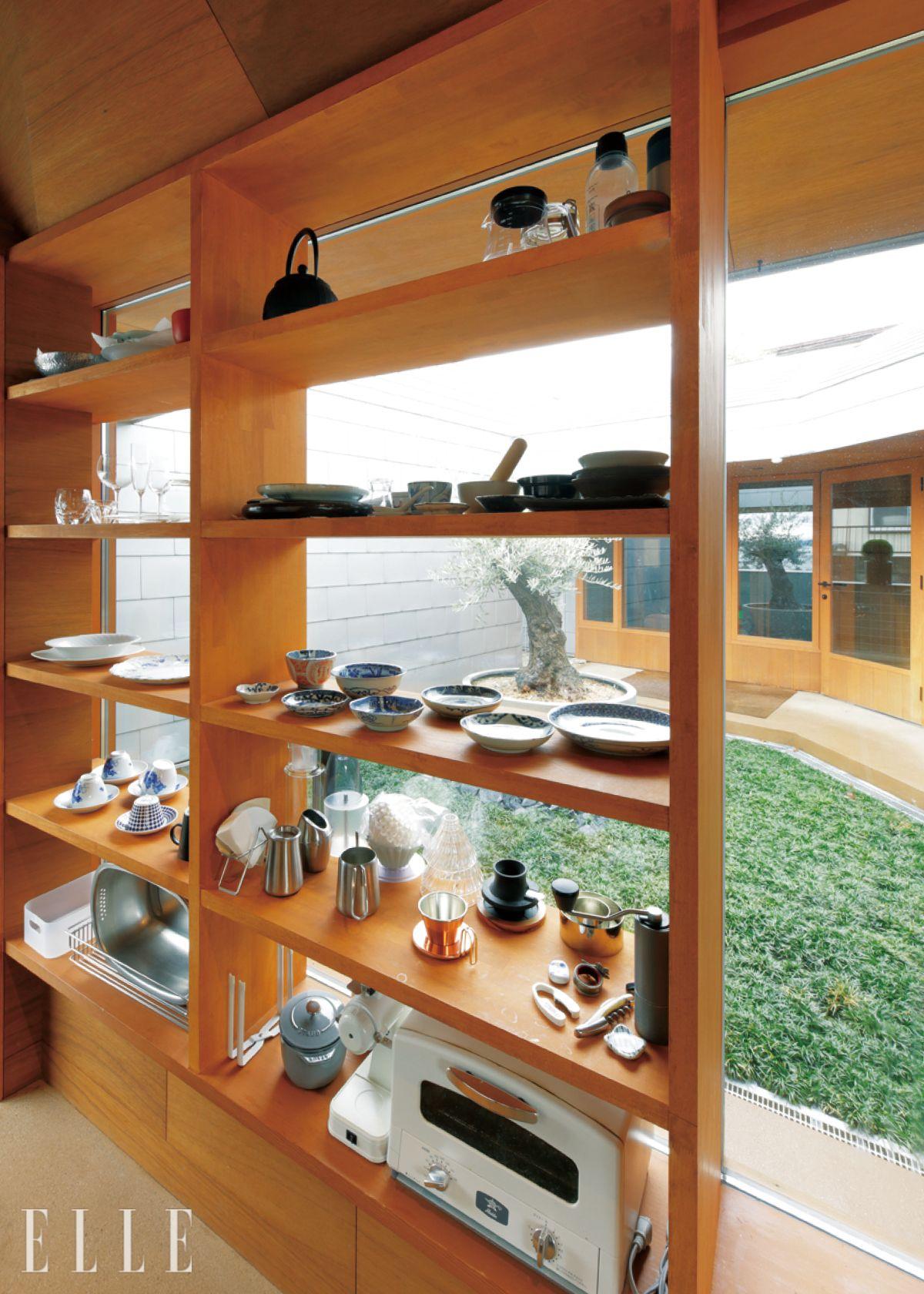 요리를 즐기고 그릇을 수집하는 부부를 위해 창틀과 일체형으로 설계된 오픈형 식기장을 설치했다. 빛이 들어오는 방향에 맞춰 설계해 기물 하나하나가 인테리어의 일부가 된다. 