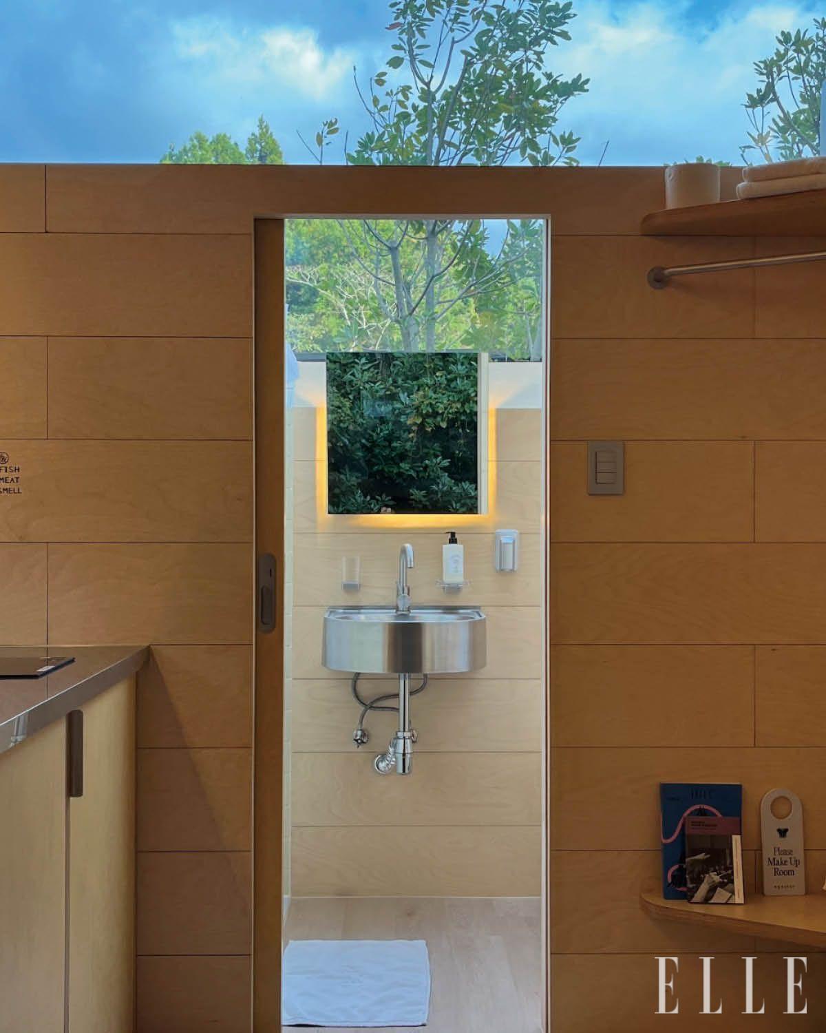 숲 풍경이 펼쳐지는 천창이 매력적인 캐빈의 욕실. 