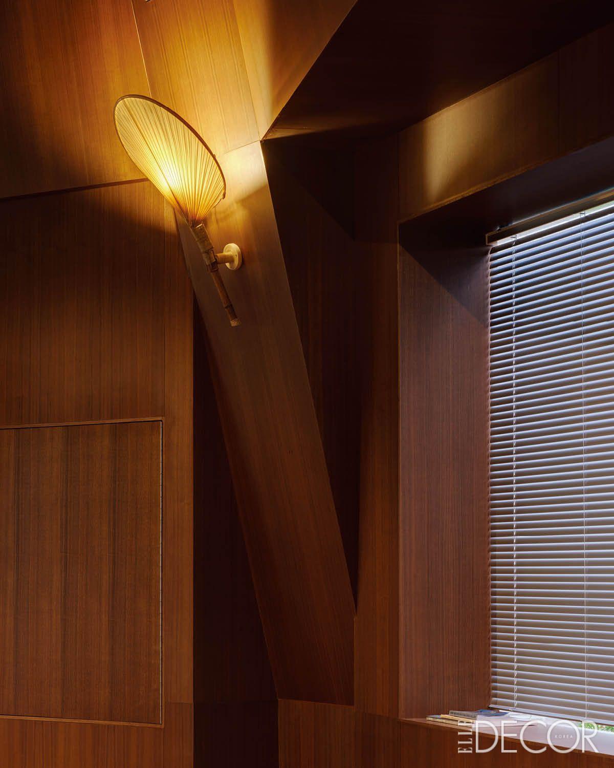 짙은 우드 벽면에 잉고 마우러의 우치와(Uchiwa) 램프를 더해 이색적인 무드를 완성한 프라이빗 카페 벽면. 