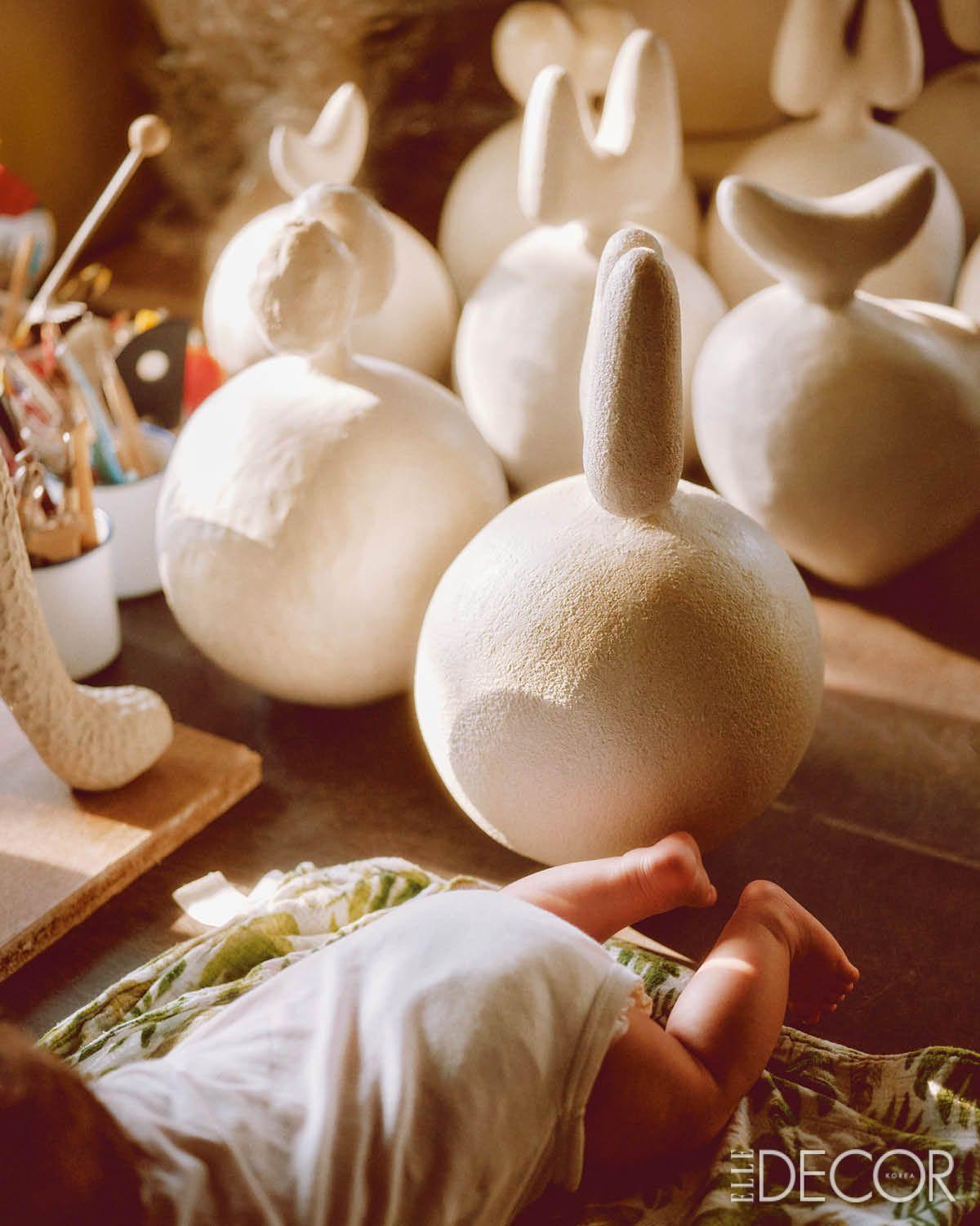 작업대 위, 막내 테츠야와 일본 달마 인형에서 영감받은 오브제들.