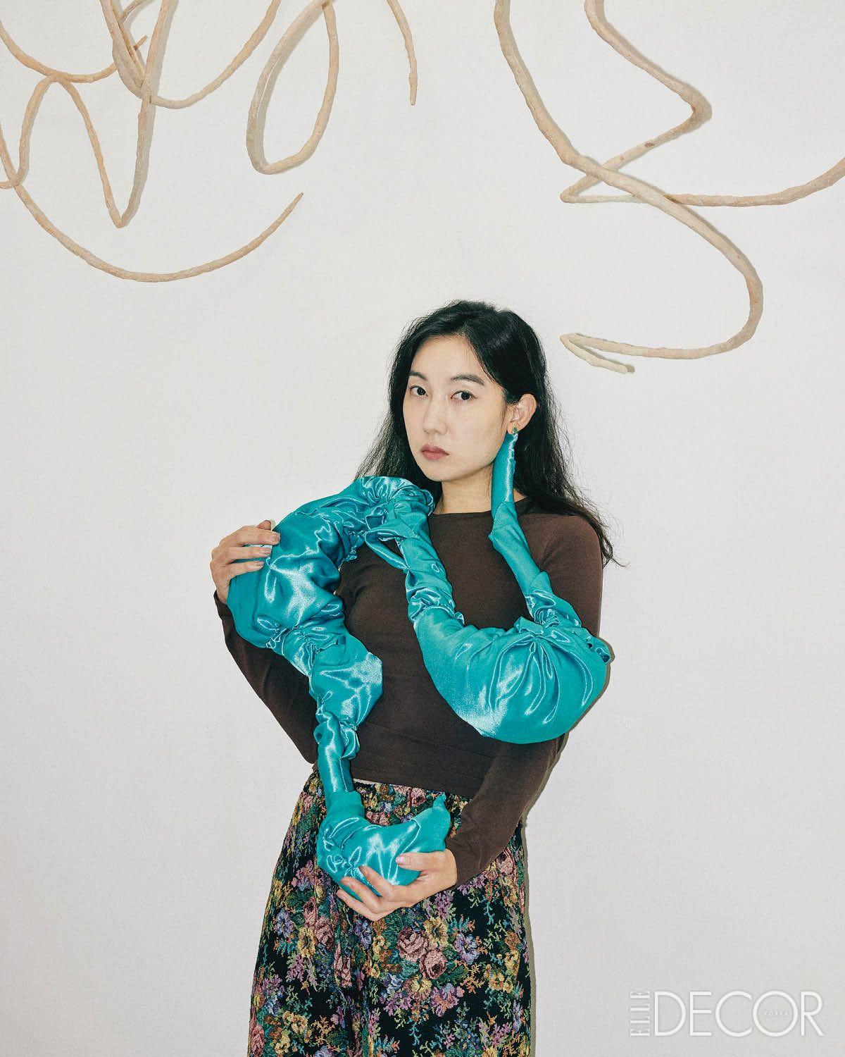 2026 아트 바젤 홍콩에서 발표할 신작 ‘Bag with you’를 들고 있는 우한나 작가. 위에는 또 다른 조각의 뼈대가 될 오브제가 매달려 있다.