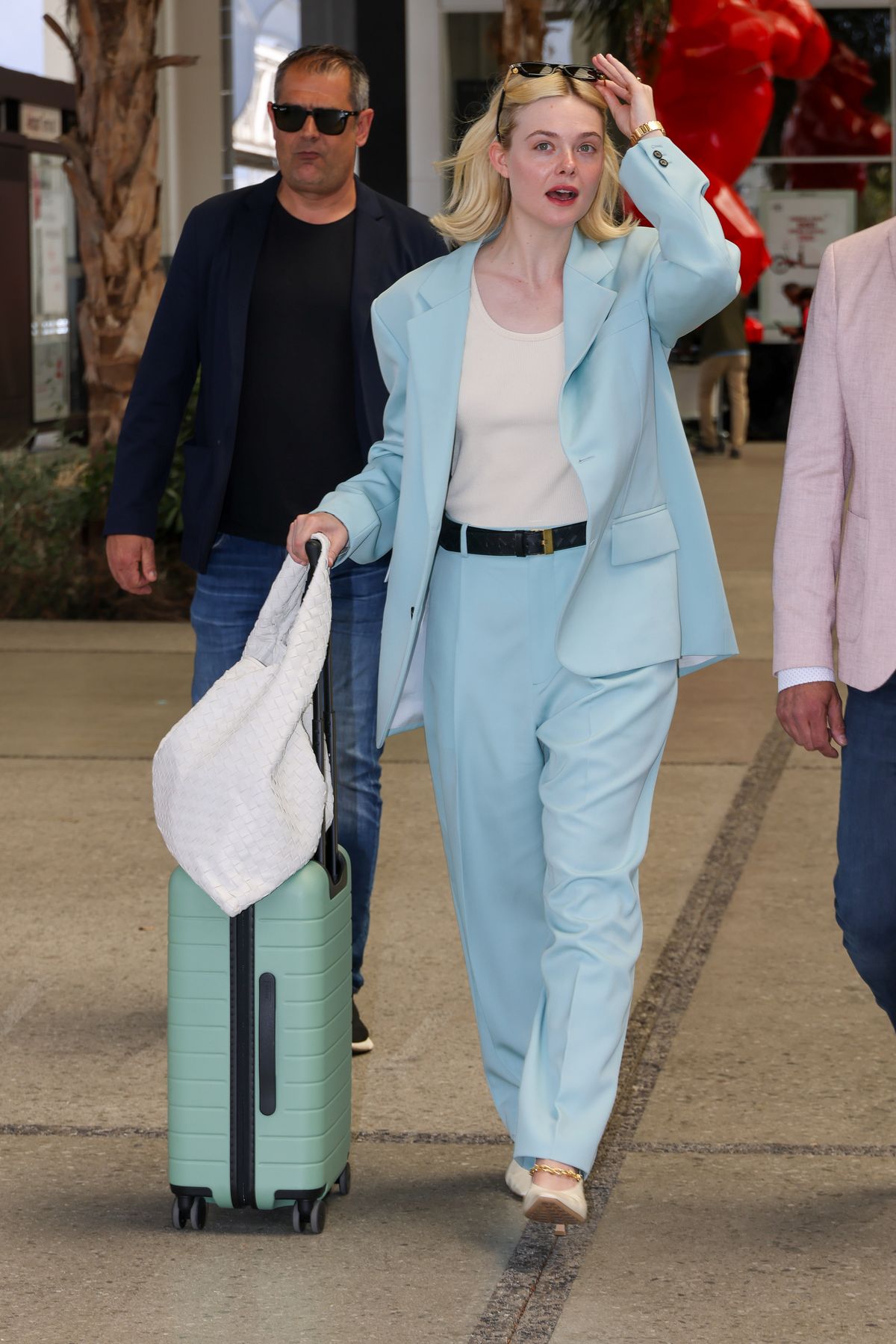 엘르 패닝은 오버사이즈 블루 수트에 산뜻한 민트 컬러의 하드 쉘 캐리어를 매치해 머리부터 발끝까지 화사한 파스텔 톤 무드를 완성했어요.