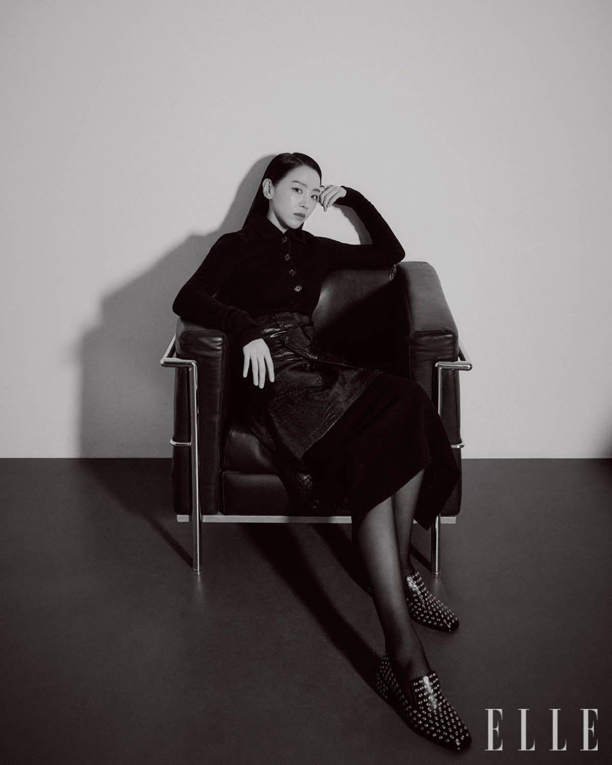 블랙 재킷과 스커트 세트업은 모두 Dolce & Gabbana. 레이어드한 레더 랩스커트는 Junya Watanabe. 오른쪽 귀에 착용한 실버 이어 커프는 Tom Wood. 왼손 검지에 착용한 실버 링은 Cos. 스터드 디테일의 블랙 로퍼는 Jimmy Choo.