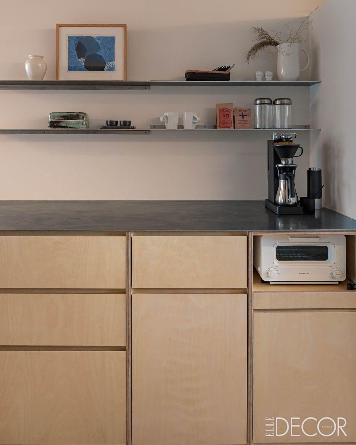 금속 선반과 따뜻한 나무 합판이 어우러진 주방.