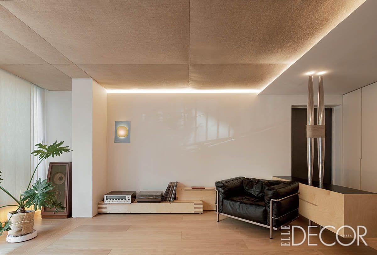 거실 한복판의 날 선 금속 기둥과 주방으로 이어지는 비어 있는 동선이 대비를 이루며 아파트 특유의 단조로움을 지워낸다. 