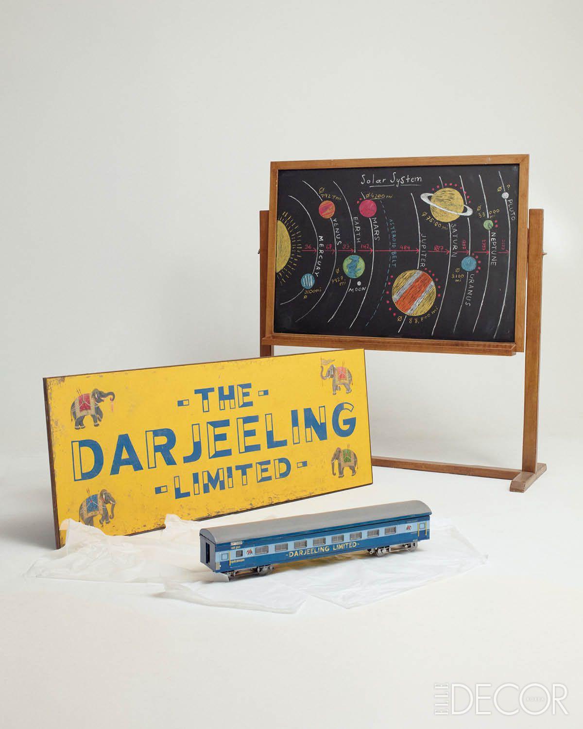 <애스터로이드 시티 Asteroid City>의 기차 미니어처 모델과 표지판과 <다즐링 주식회사>의 태양계가 그려진 칠판. 