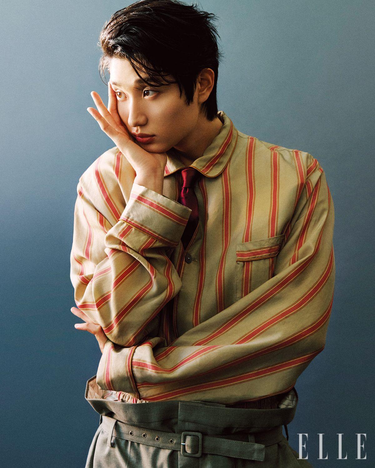 베이지 스트라이프 셔츠와 쇼트팬츠 세트업, 레드 타이와 베이지 팬츠는 모두 Saint Laurent by Anthony Vaccarello.