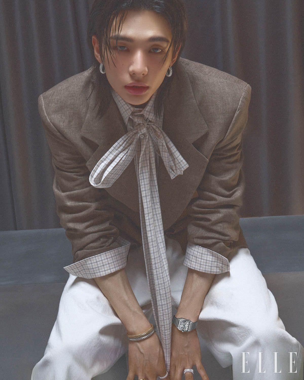 화이트골드 클래쉬 드 까르띠에 이어링과 브레이슬릿, 옐로골드 클래쉬 드 까르띠에 브레이슬릿, 화이트골드에 브릴리언트 컷 다이아몬드를 파베 세팅한 클래쉬 드 까르띠에 링, 왼손에 착용한 스틸 케이스의 산토스 드 까르띠에 워치, 화이트골드 클래쉬 드 까르띠에 더블 로우 링은 모두 Cartier. 재킷과 리본 디테일의 셔츠는 모두 Erl. 팬츠는 Ann Demeulemeester.