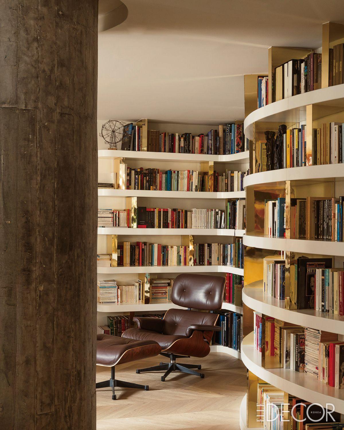서가가 중심이 되는 큰 공간. 황동 디테일은 원래 사용된 소재에 대한 은근한 오마주다. 찰스 & 레이 임스가 디자인한 비트라(Vitra) 라운지체어가 공간에 임팩트를 더한다.