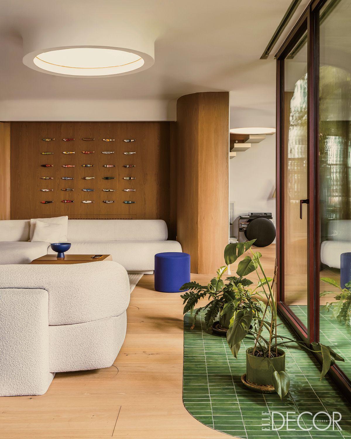 모로소(Moroso)의 고건(Gogan) 소파와 쿠션으로 꾸민 거실에는 테라스를 마감한 타일 일부를 실내로 들여왔다. 벽면 마감은 스페인산 내추럴 오크.