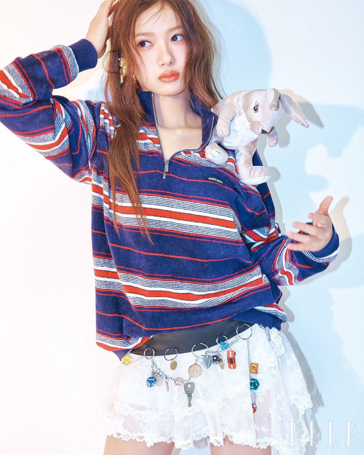 스트라이프 니트는 Miu Miu. 펜던트 장식의 화이트 레이스 스커트는 Yuhan Wang. 골드 이어링은 Yvmin.