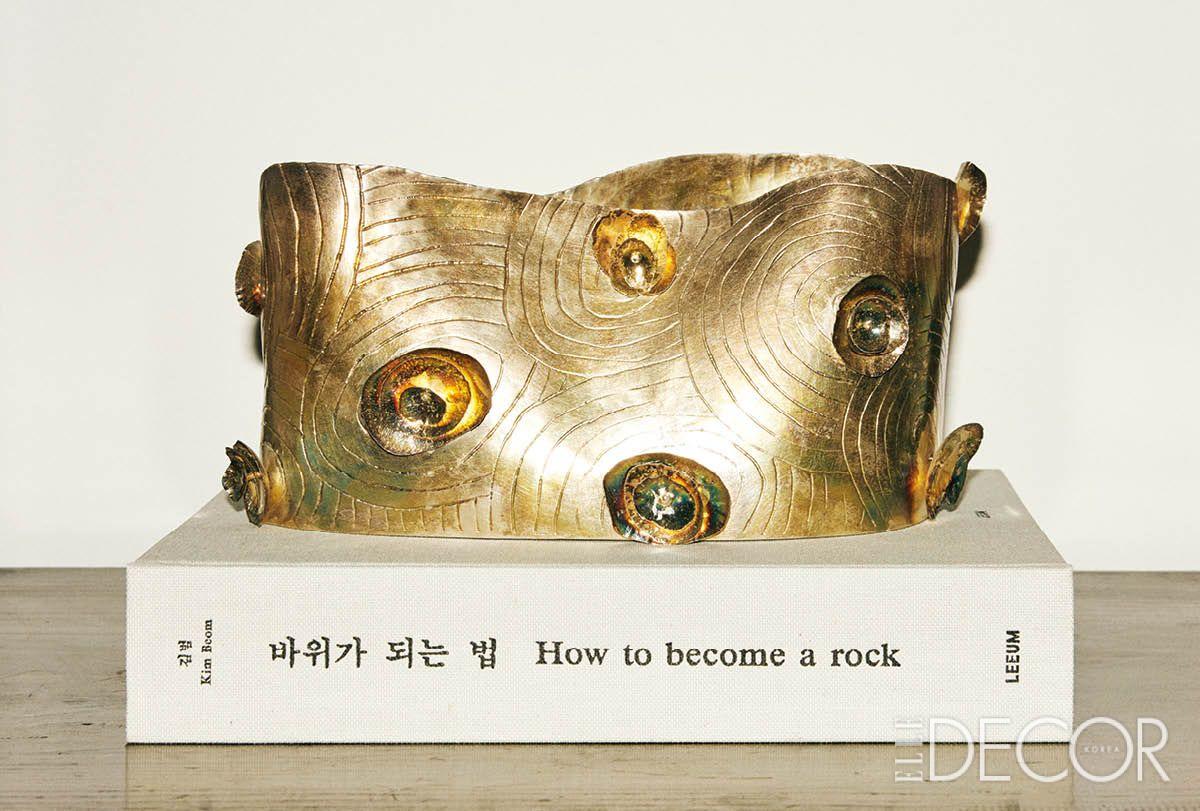 김범 작가의 작품집 <바위가 되는 법>과 윤여동 작가의 금속 오브제. 작업실 선반 위의 우연한 배치가 하나의 문장처럼 읽힌다. 
