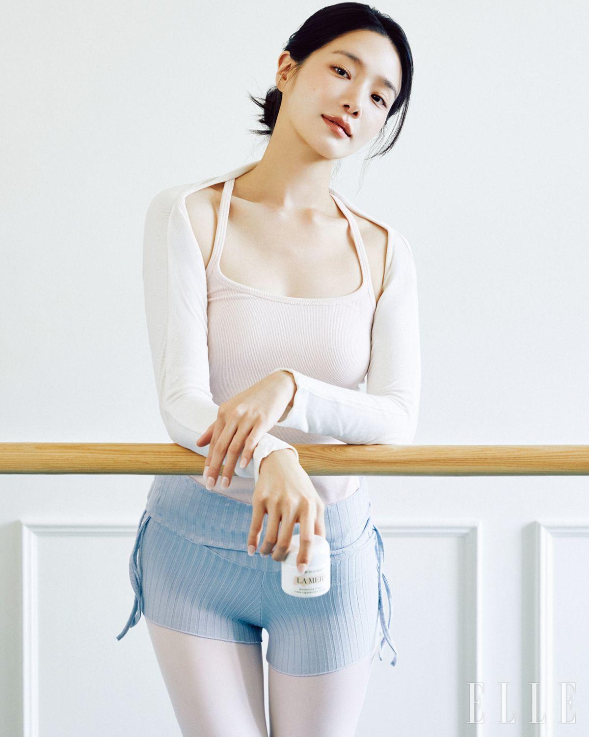 몸을 유연하게 풀어 긴장을 해소하는 과정은 스스로를 정돈하는 ‘능동적 휴식’의 출발점이 된다. 박규영에게도 휴식이란 가만히 멈춰 있는 정적인 상태가 아닌, 애정을 듬뿍 담아 나를 들여다보고 가꾸는 시간이다. 스스로 다정하게 아껴주는 순간 속에서 일상을 단단히 채워줄 에너지를 얻는다. 발레 바 곁에서 우아한 포즈를 취한 그녀의 손끝에 들려 있는 건 크렘 드 라 메르, 60ml 59만원대, La Mer. 볼레로와 이너 웨어, 쇼츠는 모두 Devi-Wear. 스타킹과 레그 워머는 스타일리스트 소장품. 발레 슈즈는 Repetto.