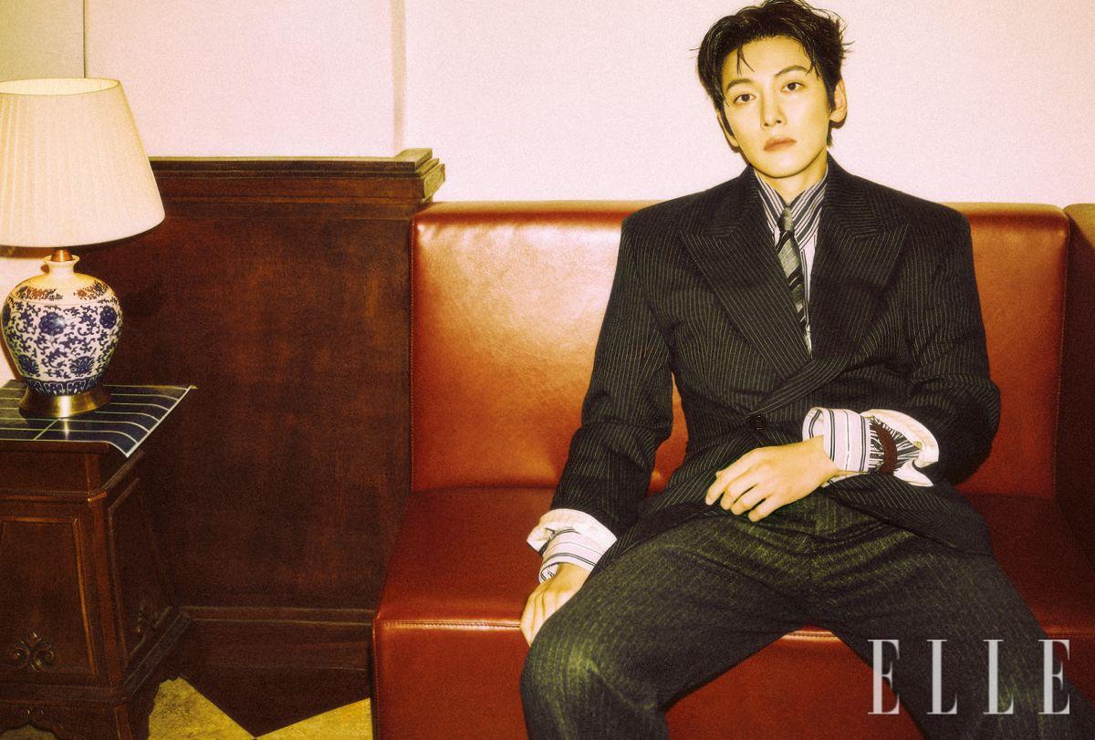핀스트라이프 수트와 셔츠, 타이, 브레이슬릿은 모두 Saint Laurent by Anthony Vaccarello.