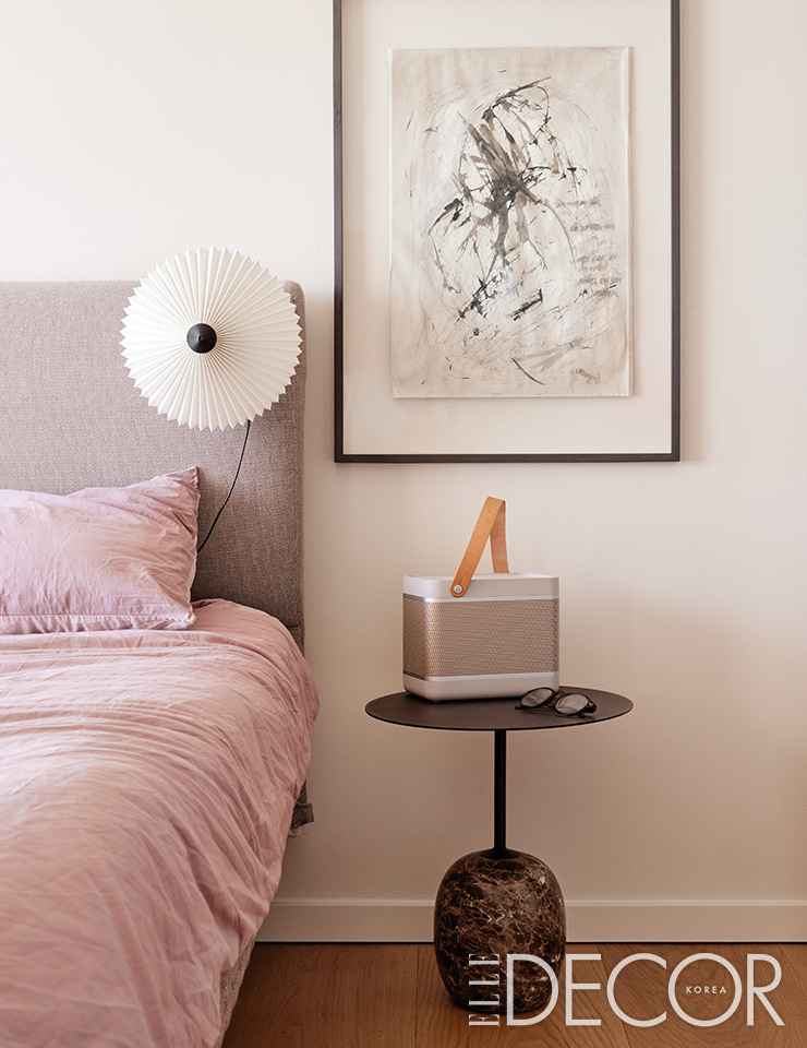 침대 헤드보드에 설치한 조명은 Hay. 롤리팝(Lollipop) 테이블은 &tradition. 스피커는 Bang & Olufsen. 그림은 덴마크 아티스트 피터 스코브가르드(Peter Skovgaard)의 작품.
