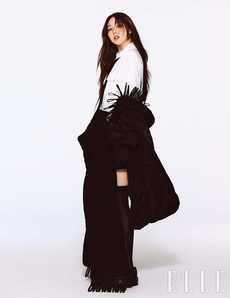 태슬 장식의 케이프 코트와 화이트 셔츠, 미니스커트, 로퍼는 모두 Louis Vuitton.
