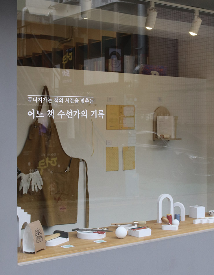 독립서점 땡스북스 쇼윈도에 펼쳐진 <어느 책 수선가의 기록> 전시 전경. 