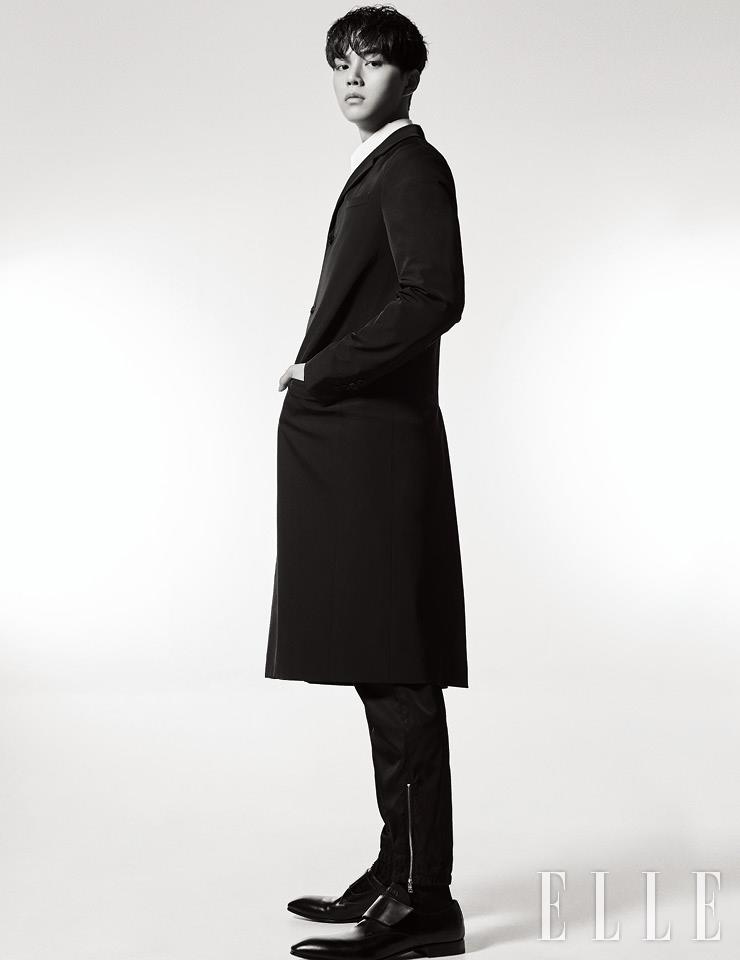 슬림한 라펠의 미디 코트와 지퍼 장식의 팬츠, 화이트 셔츠, 더비 슈즈는 모두 Prada.