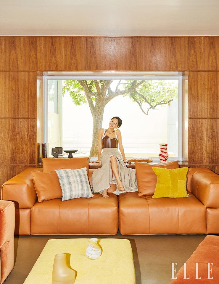 비하르 더블 4인 소파(브라운캐럿 컬러 브리오 가죽)는 4백30만원, 비하르 4인 소파(시나몬 컬러 라리오 벨벳)는 5백12만원, 비하르 오토만 소파(달리아 컬러 아크레 패브릭)는 69만원, 모두 Alloso. 화이트 톱은 EENK. 브라운 레더 뷔스티에는 Recto. 맥시 스커트는 Max Mara. 이어링, 뱅글은 스타일리스트 소장품.