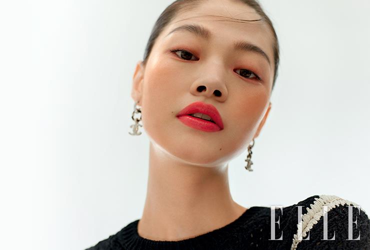 말갛게 윤기 어린 피부 위에서 선명하게 빛나는 래디언스 피니쉬의 입술이 투명한 느낌을 배가한다. N&deg;1 DE CHANEL 레드 까멜리아 립 앤 치크 밤, 2 헬시 핑크를 눈가와 볼에 얹어 생기를 더하고, 루쥬 알뤼르 렉스트레, 844를 립 라인 넘어까지 도톰하게 채워 바른다. 바움 에쌍씨엘 글로우 스틱, 트렌스페어런트를 광대뼈와 콧등, 이마, 턱 끝에 덧바르면 물기 어린 광채 피부 완성. 사용 제품은 모두 Chanel.톱과 이어링은 모두 Chanel.