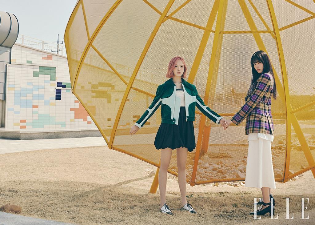 재이가 입은 멀티 컬러 재킷은 Odlyworkshop. 볼륨감이 돋보이는 원피스는 Kijun. 레이스업 슈즈는 Rachel Cox. 체인 네크리스는 Leyie. 윤이 입은 체크 재킷은 Vivien Westwood. 화이트 스커트는 Odlyworkshop. 로퍼는 Rachel Cox. 