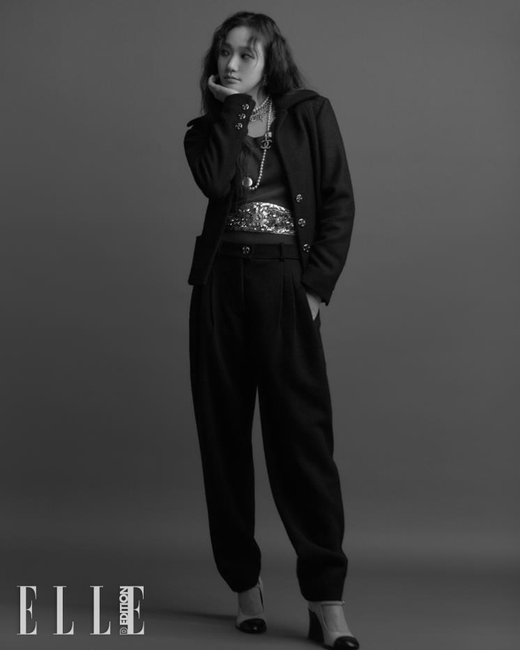 울 재킷과 팬츠, 비딩 장식의 캐시미어 풀오버, 레이어드한 네크리스, 투톤 슈즈는 모두 Chanel.