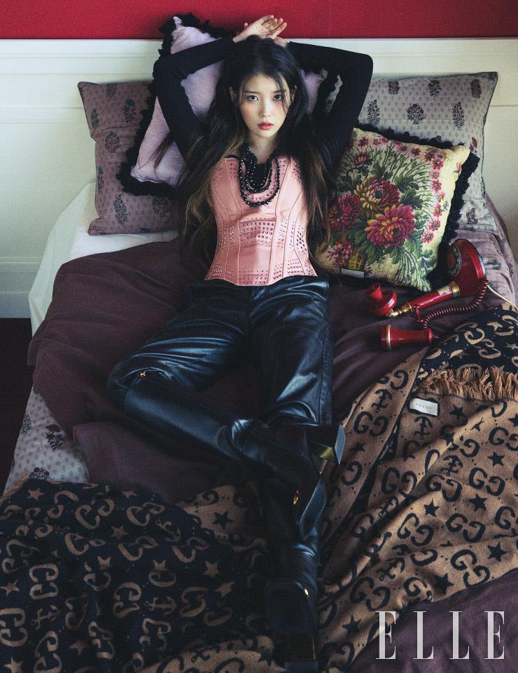 주얼 장식의 뷔스티에와 니트 톱, 가죽 팬츠, 롱부츠, 블랙 크리스털 네크리스, 플라워 자수 장식과 보라색 쿠션, 모노그램 패턴의 블랭킷은 모두 Gucci.