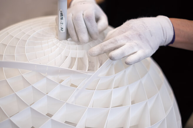 PVC로 제작된 밴드의 홈을 맞물려 조립 중인 파테라(Patera) 램프의 공정 과정.