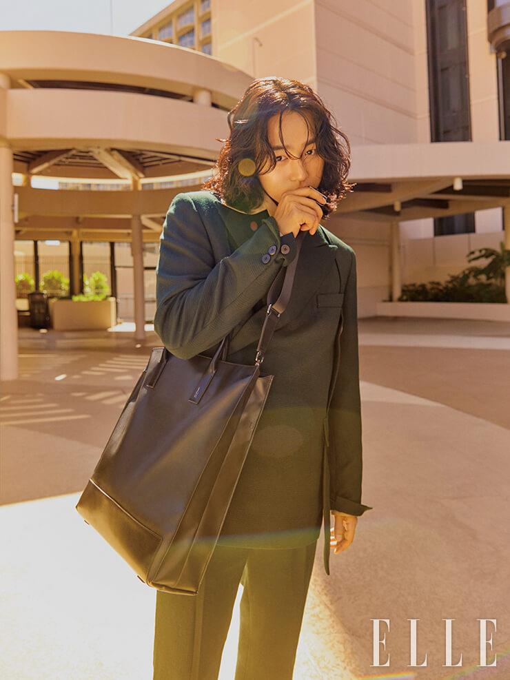 미니멀한 디자인에 탈착 가능한 숄더 스트랩으로 실용성을 높인 데이비드(David) 토트백은 Jillstuart Accessory. 피크트 라펠 재킷과 와이드 칼라 셔츠, 팬츠는 모두 Wooyoungmi.