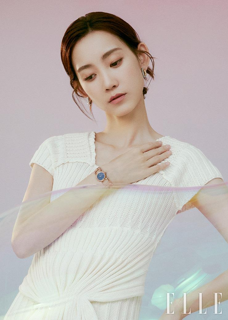 네 가지 방향 인덱스의 다이아몬드 세팅과 간치니 로고가 연결된 브레이슬릿 디자인으로 우아함을 더하는 더블 간치니 컬렉션. Ferragamo Timepiece by Gallery O’clock. 아이보리 니트 원피스는 Ports 1961. 이어링은 Salvatore Ferragamo.