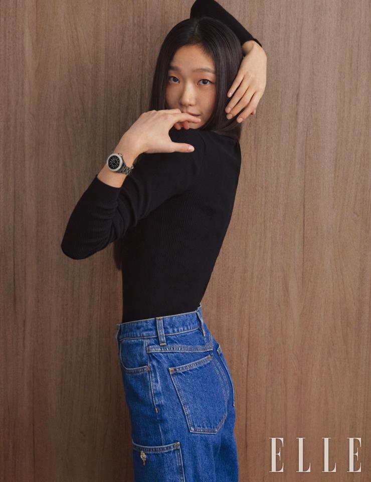 베젤에 46개의 브릴리언트 컷 다이아몬드를 세팅한 블랙 세라믹 J12 워치 33mm는 Chanel Watches. 블랙 니트 톱과 데님 팬츠는 Chanel.