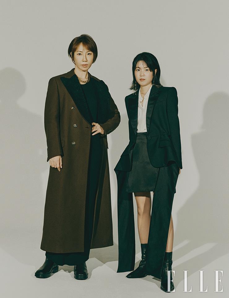 (왼쪽) 정유정이 입은 브라운 더블 브레스티드 코트와 네크리스는 모두 Tod’s. 블랙 드레스는 Arket. 조예은이 입은 블랙 재킷은 Alexander McQueen. 화이트 셔츠는 COS. 블랙 스커트는 Arket. 블랙 레더 부츠는 스타일리스트 소장품.