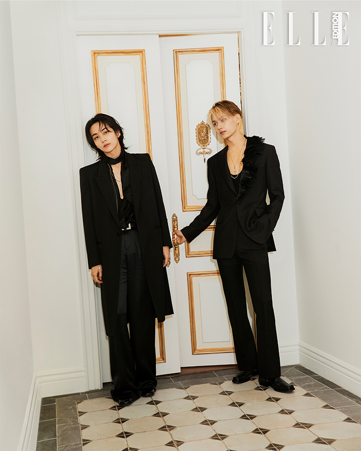 정한이 입은 브이넥 톱, 블랙 코트, 팬츠, 벨트, 네크리스, 슈즈는 모두 SAINT LAURENT BY ANTHONY VACCARELLO. 준이 이너로 입은 슬리브리스는 SAINT LAURENT BY ANTHONY VACCARELLO. 재킷은 JAYBAEK COUTURE. 팬츠는 ERNEST W.BAKER. 네크리스는 CHROME HEARTS. 슈즈는 TOGA.