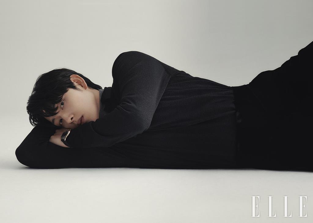 이너 웨어로 입은 그레이 터틀넥 니트 톱과 블랙 니트 톱, 블랙 팬츠는 모두 Prada. 골드 케이스 워치는 Omega.