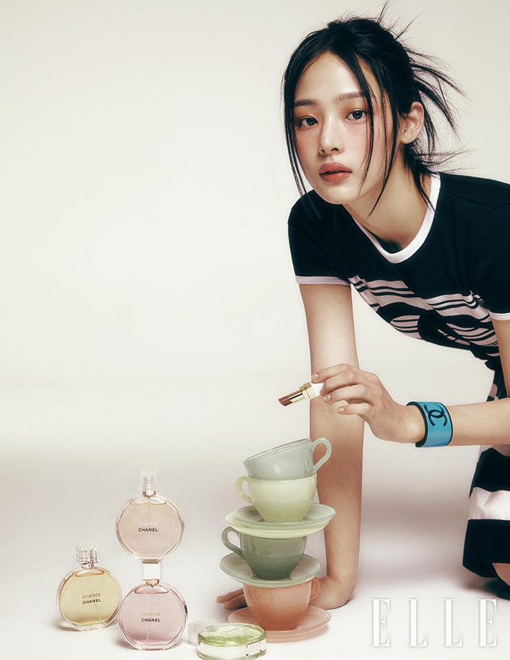 사랑스럽고 신비한 민지의 마스크를 물들인 델리스 파스텔 드 샤넬 컬렉션. 인디언 핑크와 골든 베이지 빛이 믹스된 판타지 드 샤넬로 눈가와 양볼을 물들인다. 이마와 콧등, 인중과 턱끝 등 하이라이트가 필요한 부위에 리미티드로 출시된 바움 에쌍씨엘 글로우 스틱, 드라지를 가볍게 두드려 발라 투명한 핑크빛 윤기를 더한 뒤 브라운 모브 톤의 루쥬 코코 밤, 930 스윗 트릿을 입술에 발라 시크미를 한 스푼 더했다. 사용 제품은 모두 Chanel. (왼쪽부터 순서대로) 핑크 페퍼콘과 앰버가 가미된 플로럴 스파이시 노트의 샹스 오 드 뚜왈렛. 자몽과 블러드 오렌지의 상큼한 향이 생기를 더해주는 샹스 오 비브, 각 50ml 14만6천원. 재스민 앱솔루트와 로즈 에센스로 여성성이 풍부하게 강조된 플로럴 프루티 계열의 샹스 오 땅드르 오 드 빠르펭, 50ml 17만9천원. 신선한 시트러스와 활력 넘치는 티크 우드 노트가 어우러진 샹스 오 후레쉬, 50ml 14만6천원. 민지가 손에 들고 있는 루쥬 코코 밤, 930 스윗 트릿, 4만8천원, 모두 Chanel. 블랙 티셔츠와 스커트, 볼드한 블루 뱅글은 모두 Chanel.