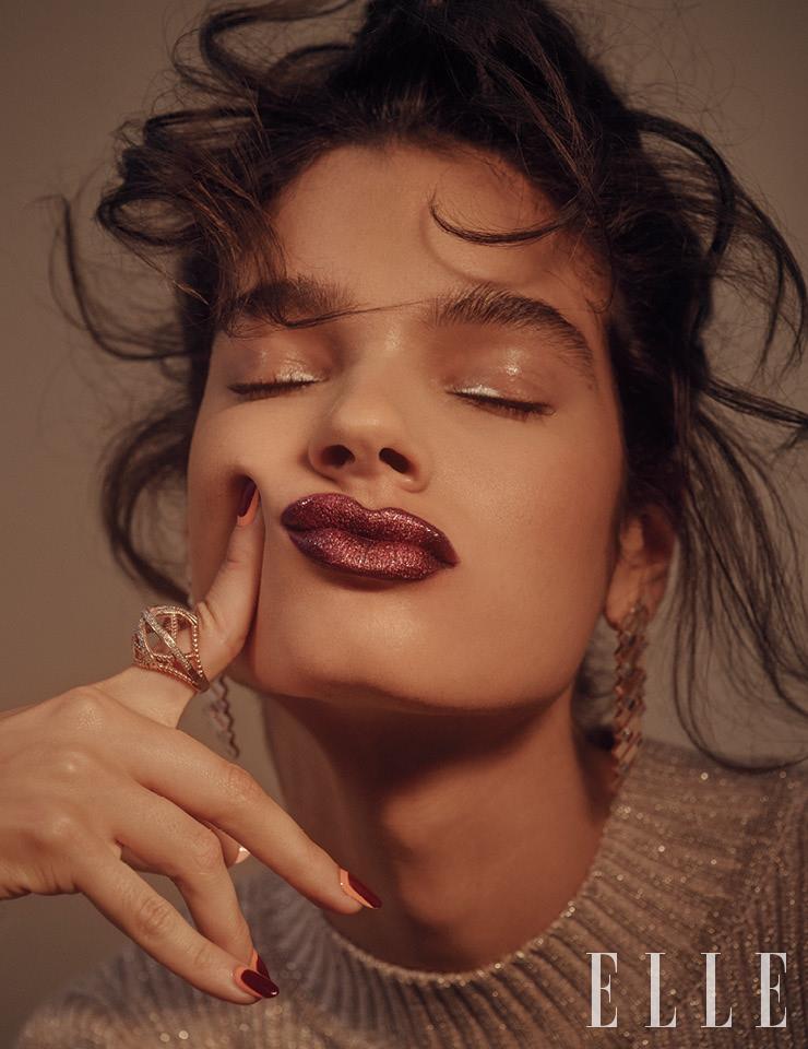  눈꺼풀에 은은한 광택을 주기 위해 Nars 멀티 유즈 글로스, 퍼스트 타임을 얇게 바르고 Make Up For Ever 스타 릿 파우더, 1 프로즌 실버를 아이라인 앞쪽에만 살짝 터치해 퓨어한 반짝임을 준다. 톤다운된 플럼빛의 Make Up For Ever 루즈 아티스트, 414 락킹 러스트를 립 라인에 꼭 맞게 메워 바른 다음, 메탈릭 옐로 골드 펄이 가득 든 Nars 멀티 유즈 글로스, 워킹 걸을 덧발라 화려한 펄감을 입힌다. 니트 드레스는 Self-Portrait. 이어링은 State Property. 링은 Nancy Newberg.