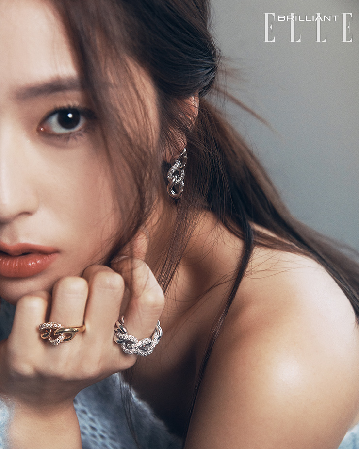  18K 화이트 골드에 다이아몬드를 부분적으로 세팅한 ‘카테네’ 이어링, 검지에 착용한 18K 화이트 골드 체인 모티프에 다이아몬드를 세팅한 ‘카테네’ 링, 약지에 착용한 18K 로즈 골드에 다이아몬드가 어우러진 ‘카테네’ 링은 모두 POMELLATO. 원숄더 니트 톱은 FORTE_FORTE.