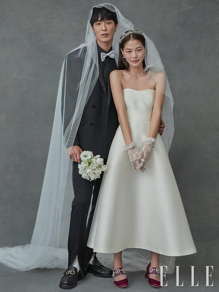 박진이 입은 블랙 재킷과 셔츠, 팬츠는 가격 미정, 모두 Berluti. 로퍼는 가격 미정, Salvatore Ferragamo. 보타이와 삭스는 스타일리스트 소장품. 김아현이 입은 튜브 드레스는 가격 미정, Bride and You. 진주 이어링은 5만8천원, Stonehenge. 티아라와 레이스 글러브, 롱 베일은 가격 미정, 모두 The Queen Lounge. 핑크 힐은 가격 미정, Roger Vivier.