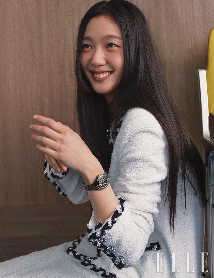 블랙 세라믹 브레이슬렛과 스틸 트리플 폴딩 버클을 장착한 J12 워치 칼리버 12.2 33mm는 Chanel Watches. 화이트 트위드 재킷과 스커트는 Chanel.
